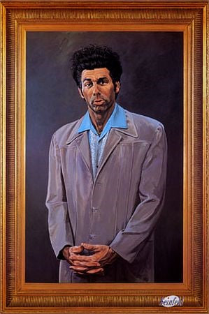 A portrait painting of a man with a bewildered expression standing against a dark background. He has dark, unruly hair and is wearing a light grey suit jacket over a collared shirt. The portrait, perfect for the Movies & TV Collection, is framed in an ornate, gold-colored frame: The Kramer Seinfeld by MTV 022.