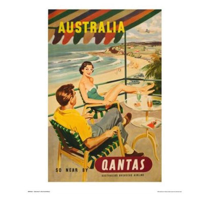 A vintage advertising art print by TAP showcasing Australia. It features a woman in a swimsuit and a man in summer attire under a striped umbrella, overlooking a sunny beach and coastline. The text reads "Australia" and "So Near By Qantas, Australia's Overseas Airline." Perfect for lovers of travel prints, the product is called Qantas - Beach.