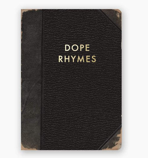 A black leather-bound Dope Rhymes Journal by Blue Dog Posters, showcasing worn edges and "DOPE RHYMES" gold foil stamped on the cover. This handy journal features dotted pages, ideal for organizing your thoughts and unleashing your creativity.