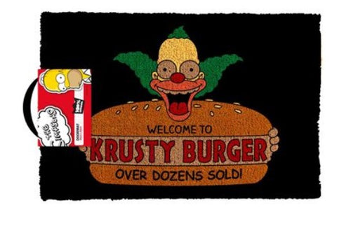 Introducing The Simpsons Welcome to Krusty Door Mat by Blue Dog Posters! This exclusive homewares item features a coir doormat depicting Krusty the Clown holding a large burger with the text "Welcome to Krusty Burger" and "Over Dozens Sold!" Set against a black background, it comes with a hanging tag showcasing Homer Simpson on the left.