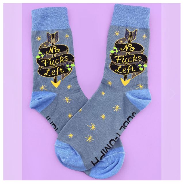 A pair of gray crew socks with blue cuffs, heels, and toes. These unisex Jubly-Umph No Fucks Left Socks by Blue Dog Posters feature a design of a black banner with the text "No Fucks Left" in yellow, accented with green stars and yellow arrows. Small yellow stars are scattered across these medium size socks.