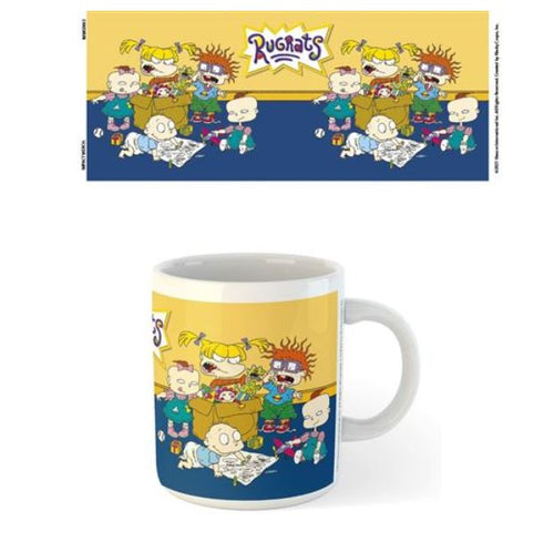 A Rugrats Mug by Blue Dog Posters featuring characters from the Rugrats cartoon. The white mug from the Homewares Collection has a sublimation-printed design showing Angelica, Tommy, Chuckie, Phil, Lil, and Dil sitting and playing against a blue and yellow background with the Rugrats logo prominently displayed above them.