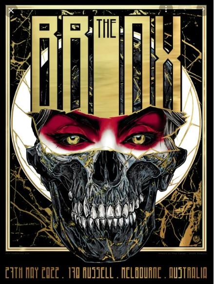 The limited edition "The Bronx Melbourne" concert poster by Blue Dog Posters features a dark and skeletal face with yellow eyes and striking red makeup. Metallic gold and black text prominently display the band's name, the date of 27th May 2022, and the venue at 170 Russell, Melbourne, Australia. The exclusive silkscreen print adds a unique touch.