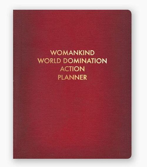 A red notebook from Blue Dog Posters called the Womankind World Domination Planner, featuring a cover stamped in gold foil with the phrase "WOMANKIND WORLD DOMINATION ACTION PLANNER" in uppercase letters. This practical journal includes both dotted and ruled pages.